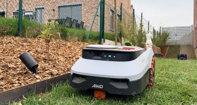 Vue rapprochée du Navimow i210 LiDAR Pro longeant une bordure en acier avec capteurs Vision et LiDAR visibles