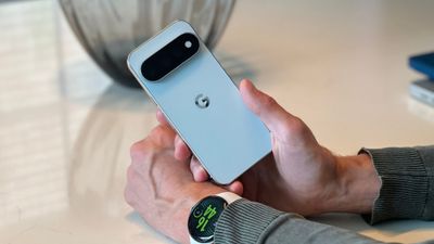 Google Pixel 11 Pro coloris Fog tenu en main, logo G et module caméra visibles, Pixel Watch 5 au poignet