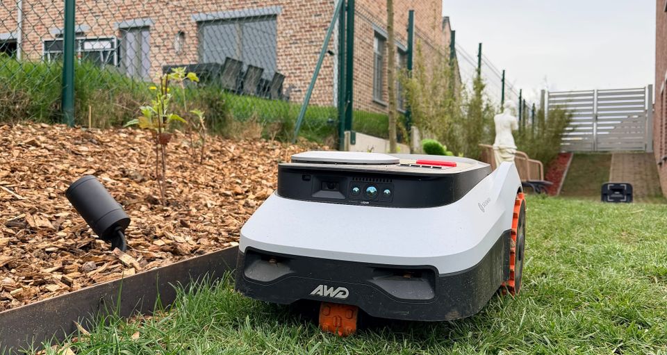 Vue rapprochée du Navimow i210 LiDAR Pro longeant une bordure en acier avec capteurs Vision et LiDAR visibles