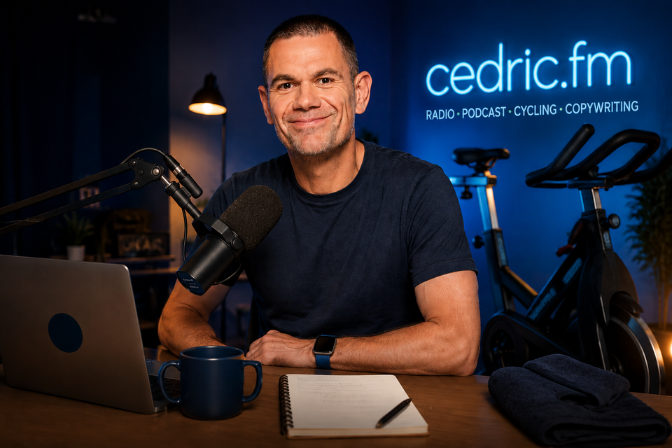 Portrait de Cédric Godart dans un studio podcast et indoor cycling avec micro radio, ordinateur portable et vélo indoor.