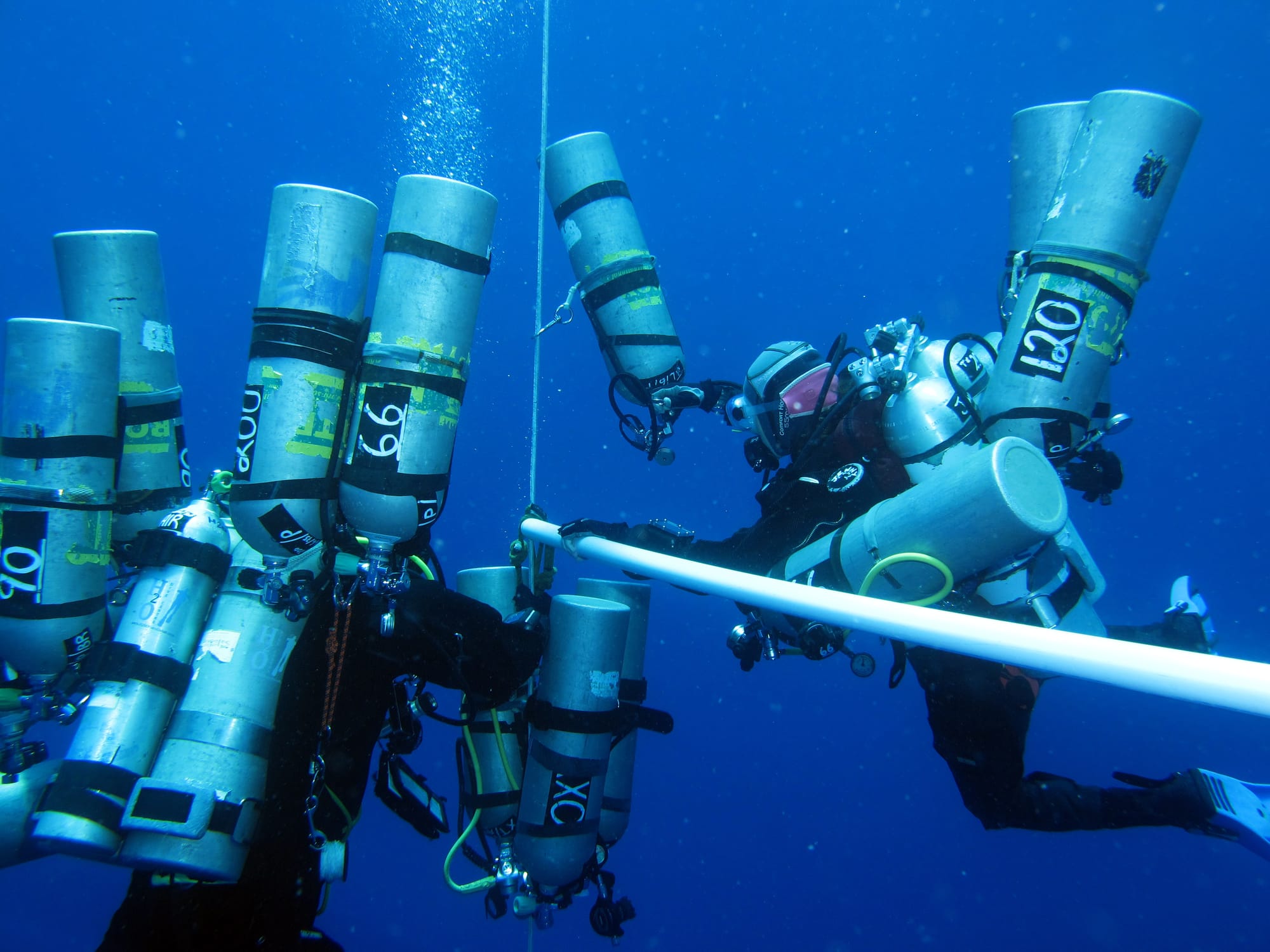 Technical divers, coming up from a deep dive, with multiple cylinders containing helium, which increases their susceptebility to HPNS or High-pressure nervous syndrome