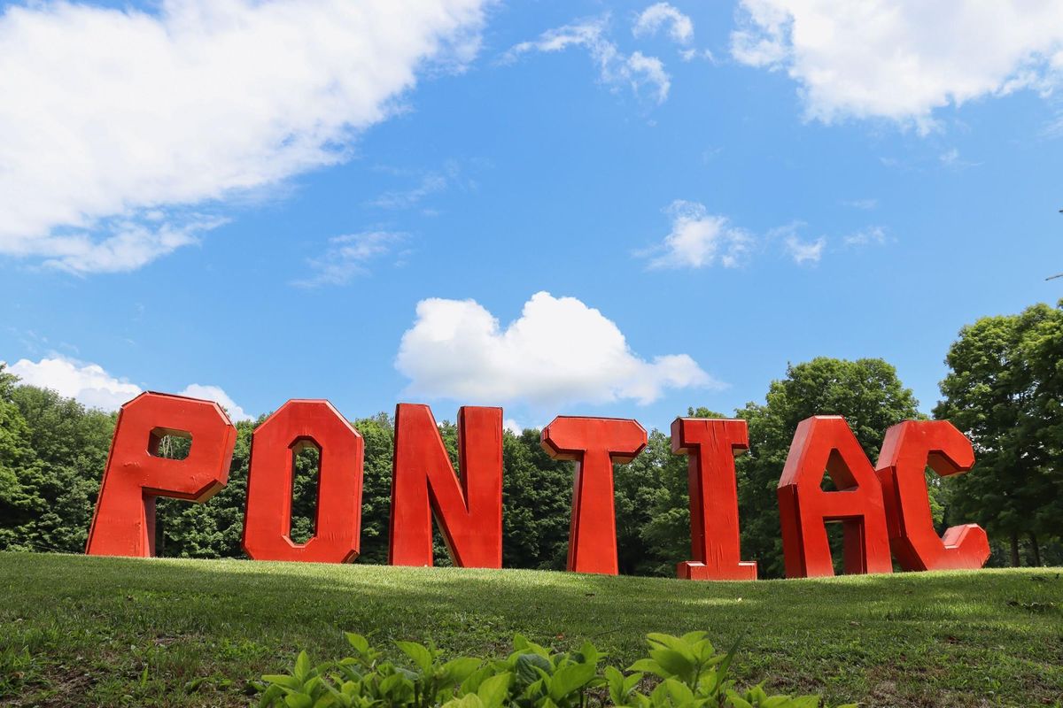 Camp Pontiac Sign with Pontiac spelled out in big red wooden letters.