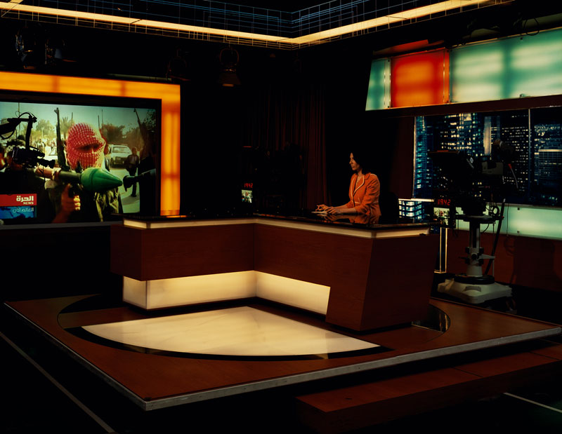Alhurra TV, Broadcast Studio<br>
Springfield, Va.<br /><br />
Anchor Mona Atari at the Alhurra news desk. Alhurra is a U.S. government-sponsored, Arabic-language television network devoted primarily to news and information. Established in Feb. 2004, the network broadcasts 24-hour, commercial-free satellite programming to an audience of 21 million weekly viewers in 22 Arab countries. In April 2004, a second, Iraq-focused channel, Alhurra Iraq, was launched.<br /><br />
Section 501 of the U.S. Information and Education Exchange Act, passed by Congress in 1948, authorizes the U.S. government to disseminate information abroad about the U.S. and its policies. Section 501 also prohibits domestic dissemination of that same information. It is therefore illegal to broadcast Alhurra domestically. Alhurra is Arabic for “the free one.”