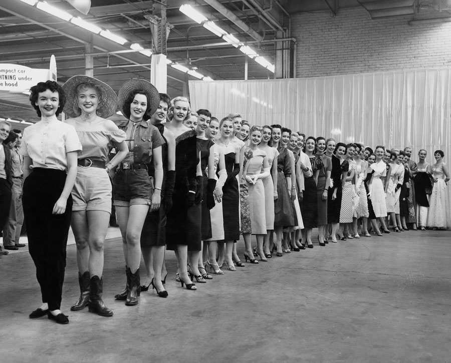 In the early 1960s, the Detroit Auto Dealers Association posed a group of auto show models before the show doors opened. The models each depicted a specific visual quality to enhance the car they were assigned to represent. The wardrobe ranged from Audrey Hepburn contemporary to Western cowgirl, New York sophisticate, Betty Crocker homemaker, and Marilyn Monroe lookalike.