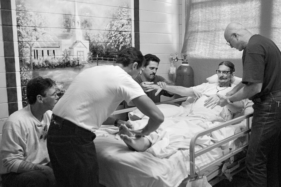 Hospice volunteer, Randolph Matthieu, far right, shows Paul Krolowitz, Carlo DeSalvo, Joseph Greco how to massage their friend Richard Liggett. Liggett is a hospice patient diagnosed with lung and liver cancers. Liggett is a carpenter at Angola prison and trained Krolowitz, DeSalvo and Greco in the carpentry shop.