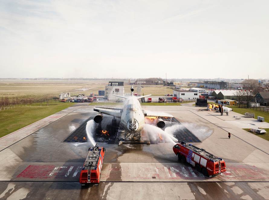 FireFly Schiphol—N-Holland, March 26, 2010. Training Center for aviation. The Schiphol fire department fighting an fire caused by leaking fuel with two fire engines. The airplane is a very realistic copy of a Boeing 747.