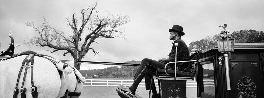 Lloyd Bone, a prisoner at Louisiana's State Penitentiary, rides atop a horse driven hearse carrying the body of fellow prisoner George Alexander, who died at the age of 56.  Bone and the hearse he and prison carpenters hand built is an example of how prisoners with the support of the Burl Cain, Angola's Warden, have created dignified funerals for inmates who are buried at the Prison graveyard.