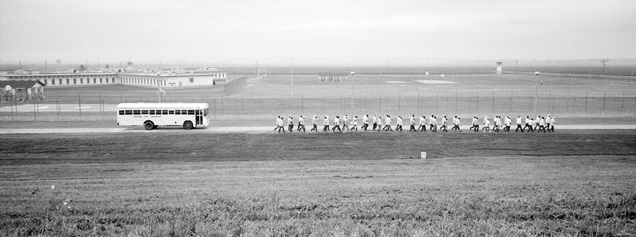 Prisoners walk in lines from the main prison to a bus pick up point inside Angola State Penitentiary.