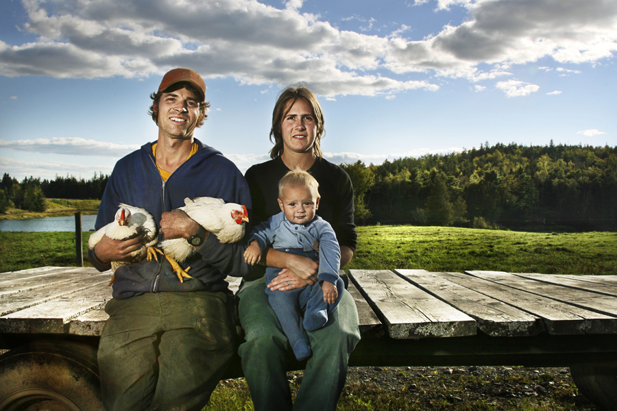 AARON BELL and CARLY DELSIGNORE with their son, HENRY, organic dairy, Edmunds, Maine<br /><br />
Jane Bell (not pictured; mother of Aaron Bell): “We all know with farming, it’s just very precarious; you’re hanging on by your fingernails, often with the whims of the weather. We once lost 14 head of cattle in a single strike of lightning. Aaron and Carly had a beautiful herd of purebred Hereford cows, just fat and healthy, and many moms and yearlings. And then on June 29th, 2005, we had a little microburst here. Picnic tables went flying and it was bolt after bolt of lightning. Aaron was in a tractor in the middle of a field, and he didn’t think he was going to get out alive. We didn’t find the cows for a day. Nobody really did a head count right away. <br /><br />
Fourteen were killed by one bolt of lightning. Seven of them were due to calve within a month, so it was really like losing 21. We worked from eight in the morning until three in the afternoon burying them. Just a horrendous day. It was a horrible feeling of loss and probably a little anger that, of all the thousands of trees, why did it have to be the one the cows were under? They were supposed to be Carly and Aaron’s down payment for the organic dairy herd. A lot of people say, ‘Well, you had them insured, didn’t you?’ But in eastern Maine, do you insure cows from lightning? Whoever heard of such an absurd thing? Of all the 200 years worth of stories about this place, it’s the first time we know of animals dying from lightning. Well, their cows are insured now.<br /><br />
But you had to be thankful that none of the houses were hit, and no humans died. You had to be thankful for that.”