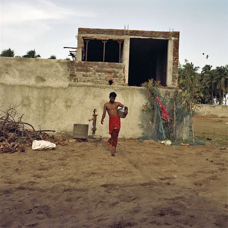 Dinesha carries water into the temple in Devanipattinam. September 2014.