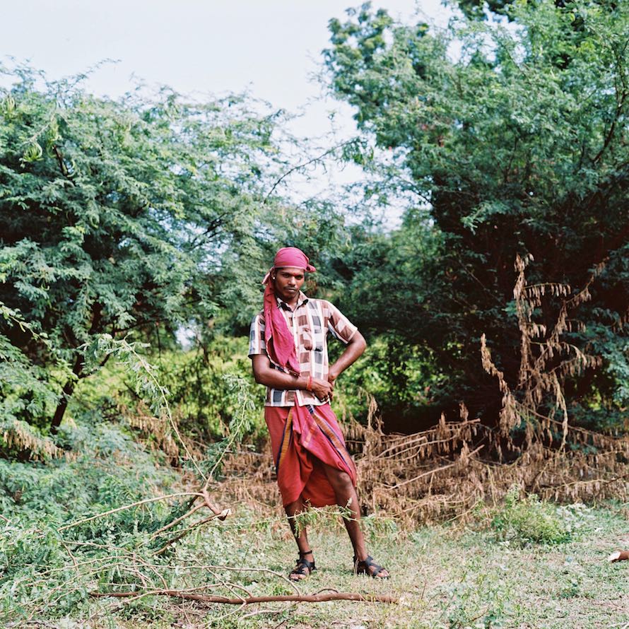 Chitra, a kothi priest from outside of Cuddalore, poses for a portrait while cutting down wood used for cooking. Many kothis choose to do this kind of work, which is traditionally done by women, as another way to express their female identity. November 2013.