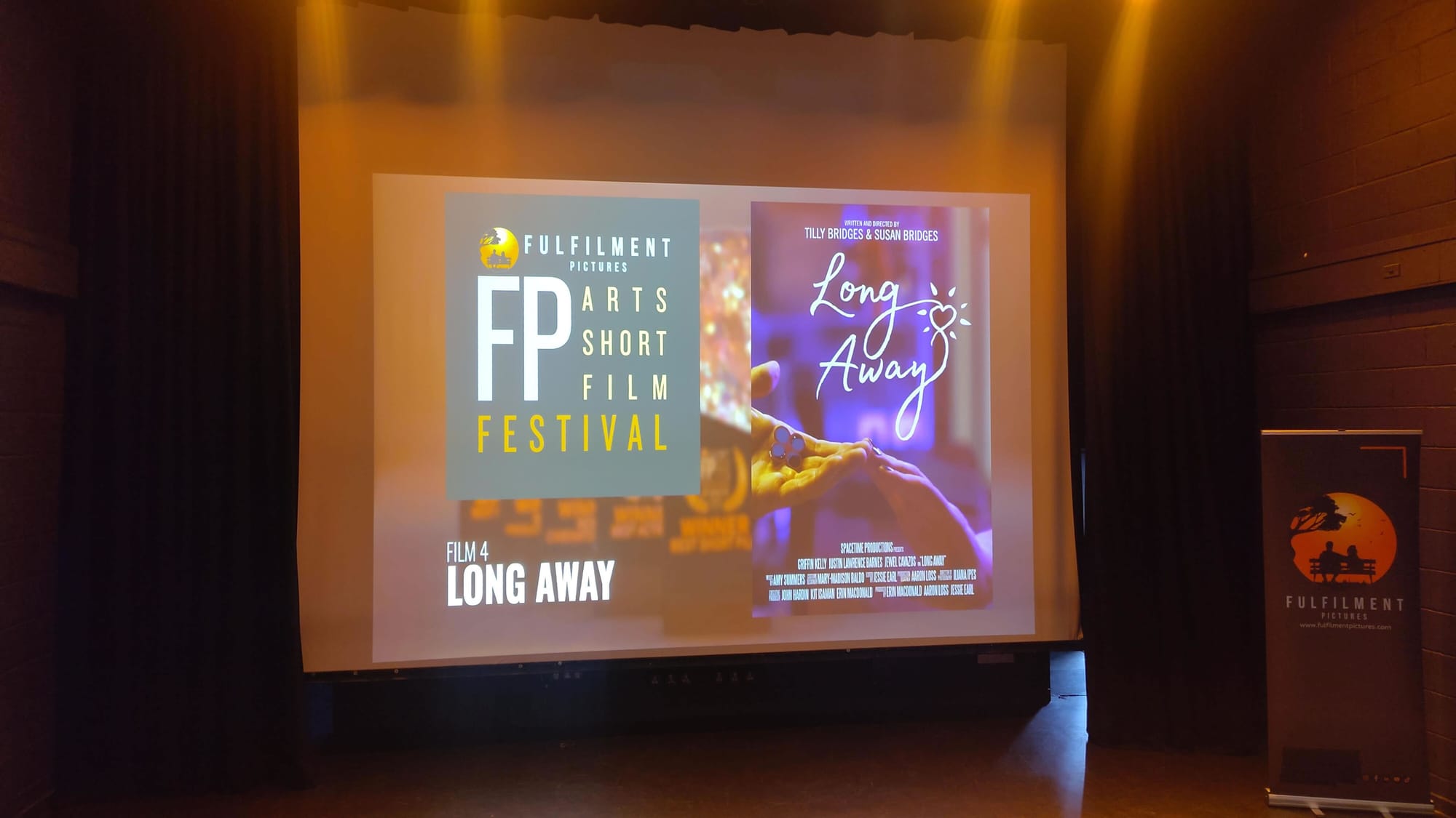 FP Arts Short Film Festival title card on screen, next to the Long Away key art poster