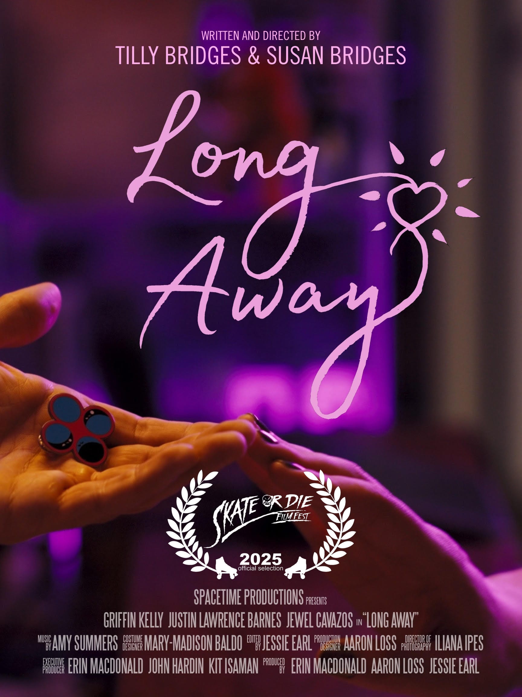 one hand reaching out, palm upward, holding an enamel pin displaying four circles, and another hand reaching out, palm downward, the two hands touch at the fingertips and are bathed in pink light. text reads: LONG AWAY WRITTEN AND DIRECTED BY TILLY BRIDGES & SUSAN BRIDGES SPACETIME PRODUCTIONS PRESENTS GRIFFIN KELLY JUSTIN LAWRENCE BARNES JEWEL CAVAZOS in “LONG AWAY” MUSIC BY AMY SUMMERS COSTUME DESIGN MARY-MADISON BALDO EDITED BY JESSIE EARL PRODUCTION DESIGNER AARON LOSS DIRECTOR OF PHOTOGRAPHY ILIANA IPES EXECUTIVE PRODUCER ERIN MACDONALD JOHN HARDIN KIT ISAMAN PRODUCED BY ERIN MACDONALD AARON LOSS JESSIE EARL Skate or Die FilmFest 2025, official selection
