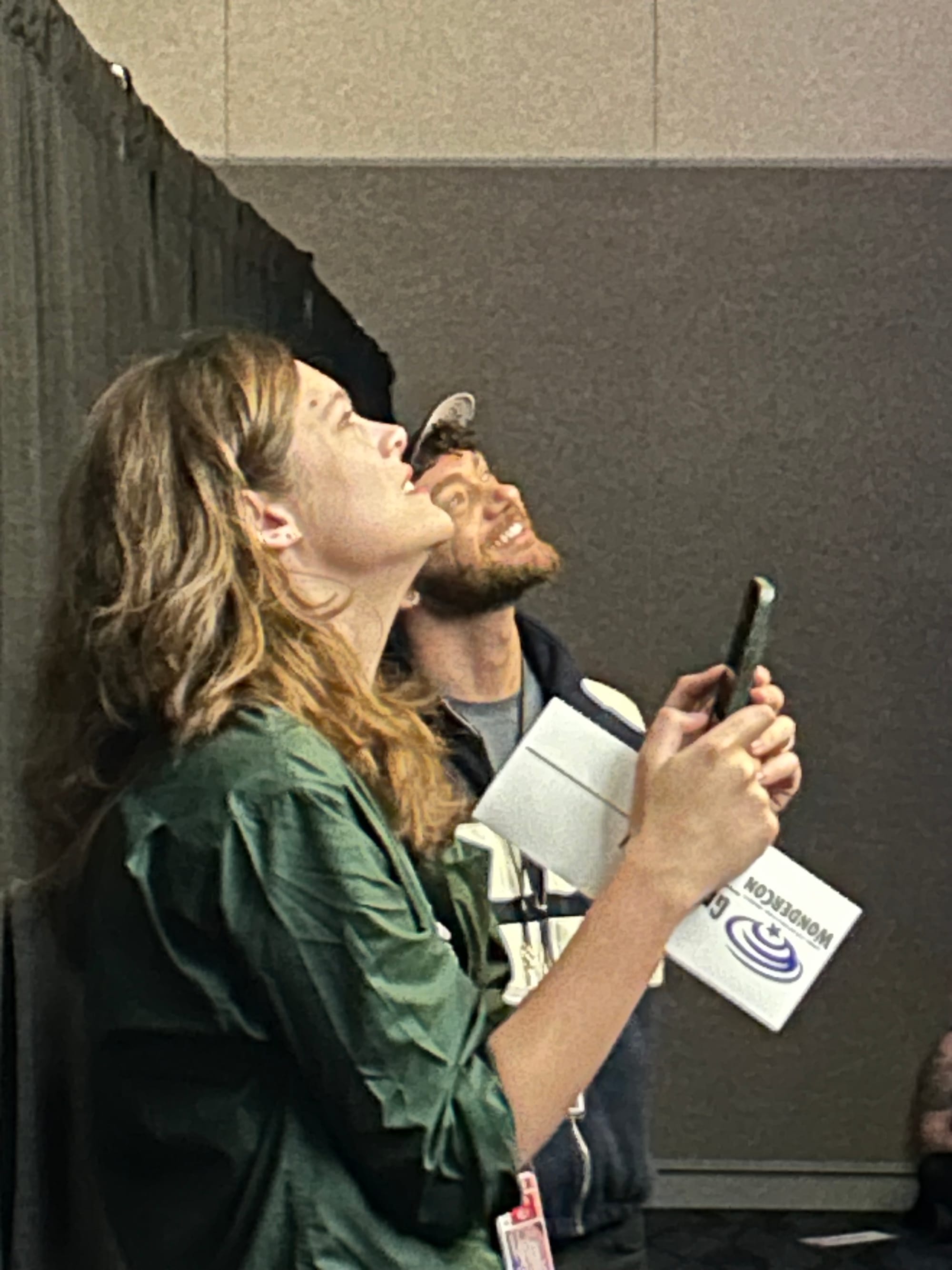 Griffin Kelly and Justin Lawrence Barnes looking up at a movie screen, bathed in its light, smiling.
