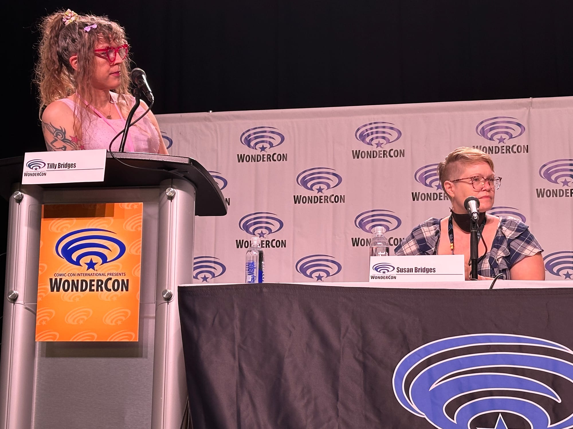 Tilly at a podium moderating the panel, Susan sitting next to her at a microphone