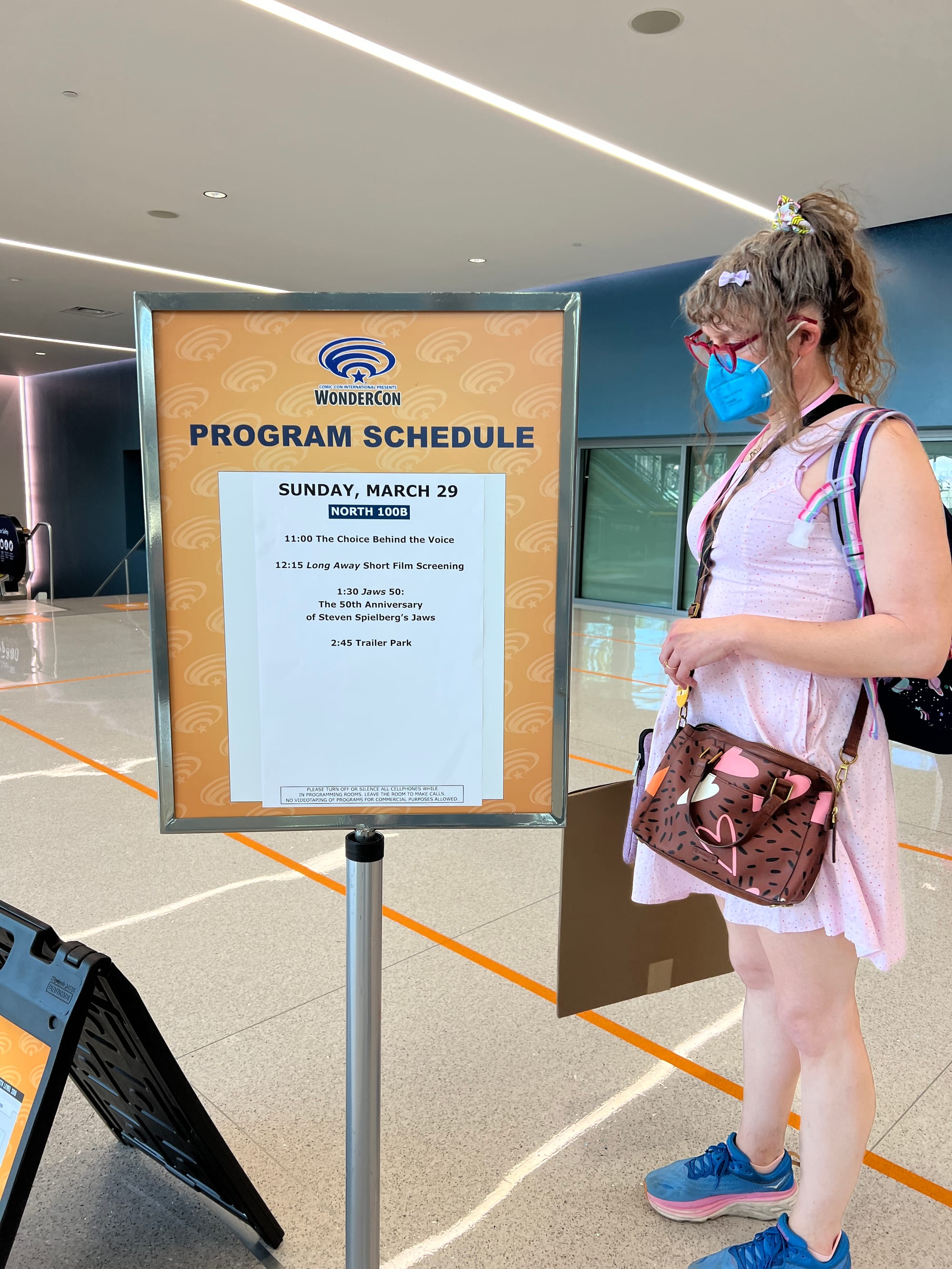 Tilly standing next to the Sunday, March 29 program schedule for panel room North 100B. 11:00 The Choice Behind the Voice, 12:15 Long Away short film screening, 1:30 Jaws 50: the 50th anniversary of Steven Spielberg’s Jaws, 2:45 Trailer Park