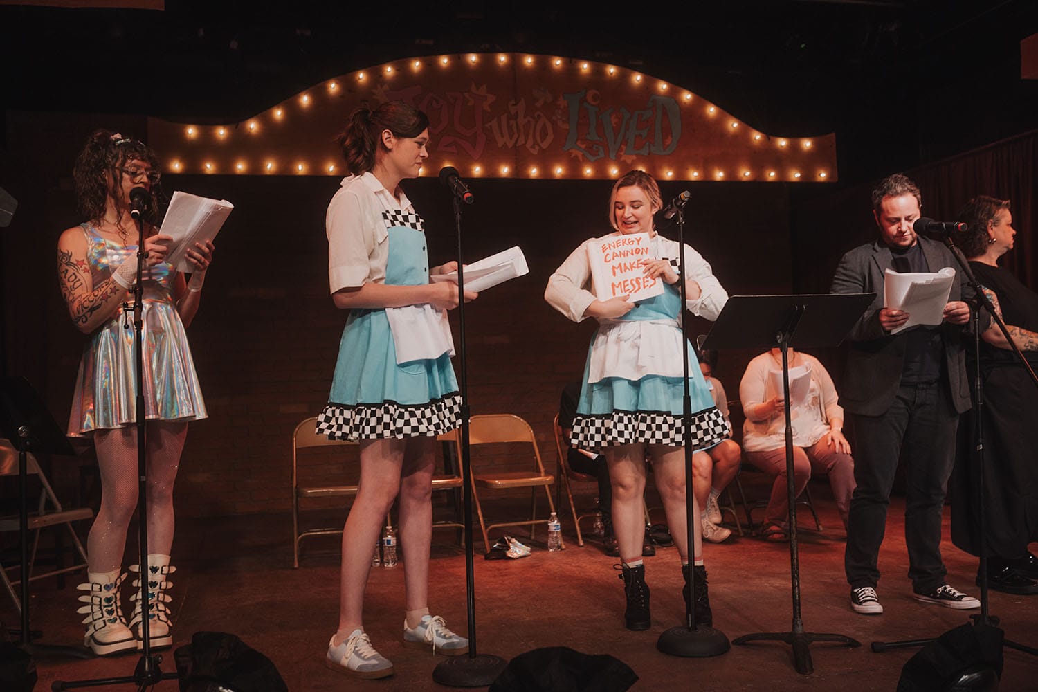 Jacks McLaughlin as Anika showing a page in her script, written with messy red lettering, that reads “energy cannon makes messes”