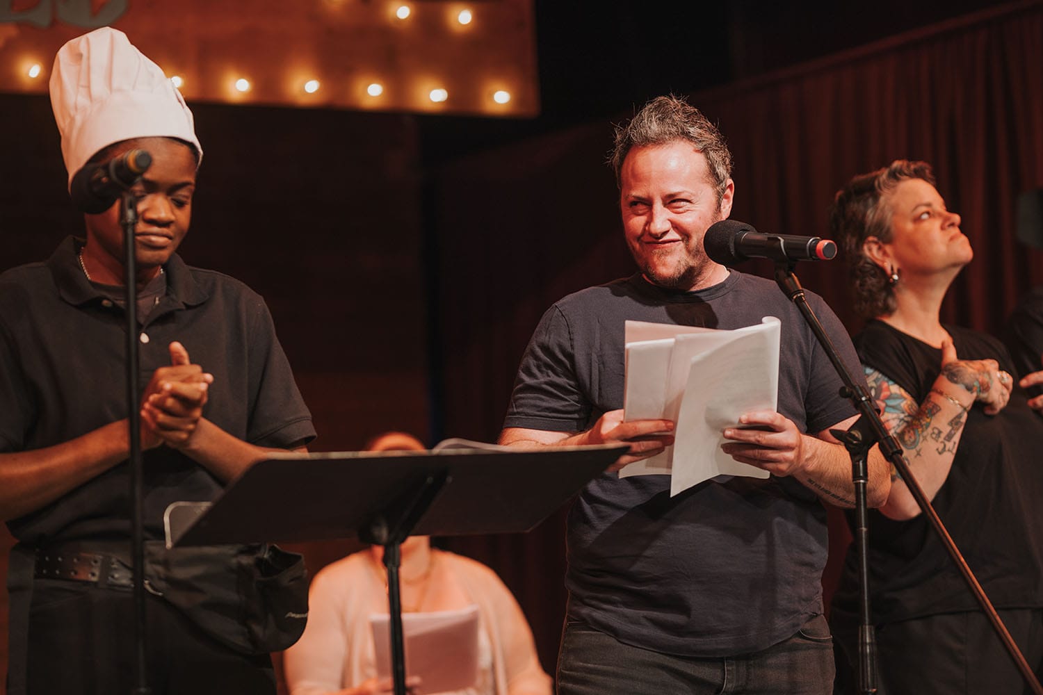 Olabisi Kovabel in a chef hat next to Kacy Boccumini as he smirks