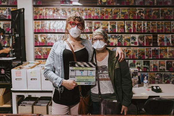 Tilly and Susan on the “Long Away” set, holding a film slate that says “Long Away Scene 1 Take 1”
