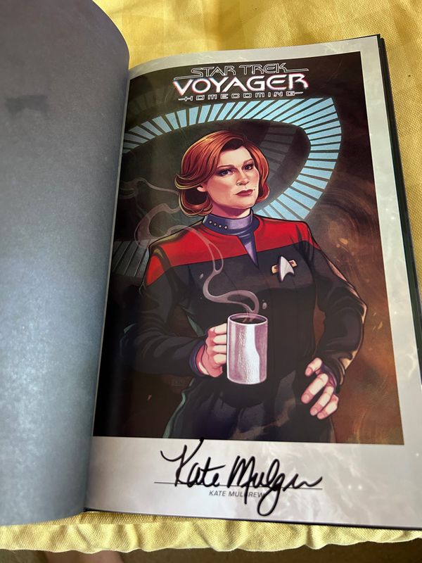 Captain Janeway comic cover art on an interior book page, signed by Kate Mulgrew