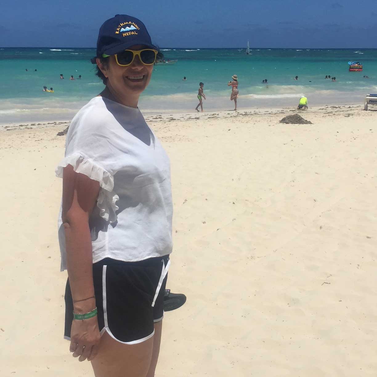 Sarah smiling on a sunny beach