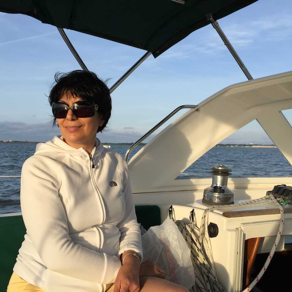Sarah sitting on a boat in a white jacket