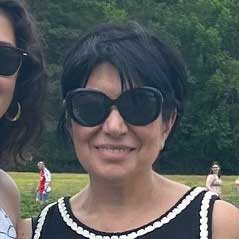 Sarah smiling outdoors in sunglasses