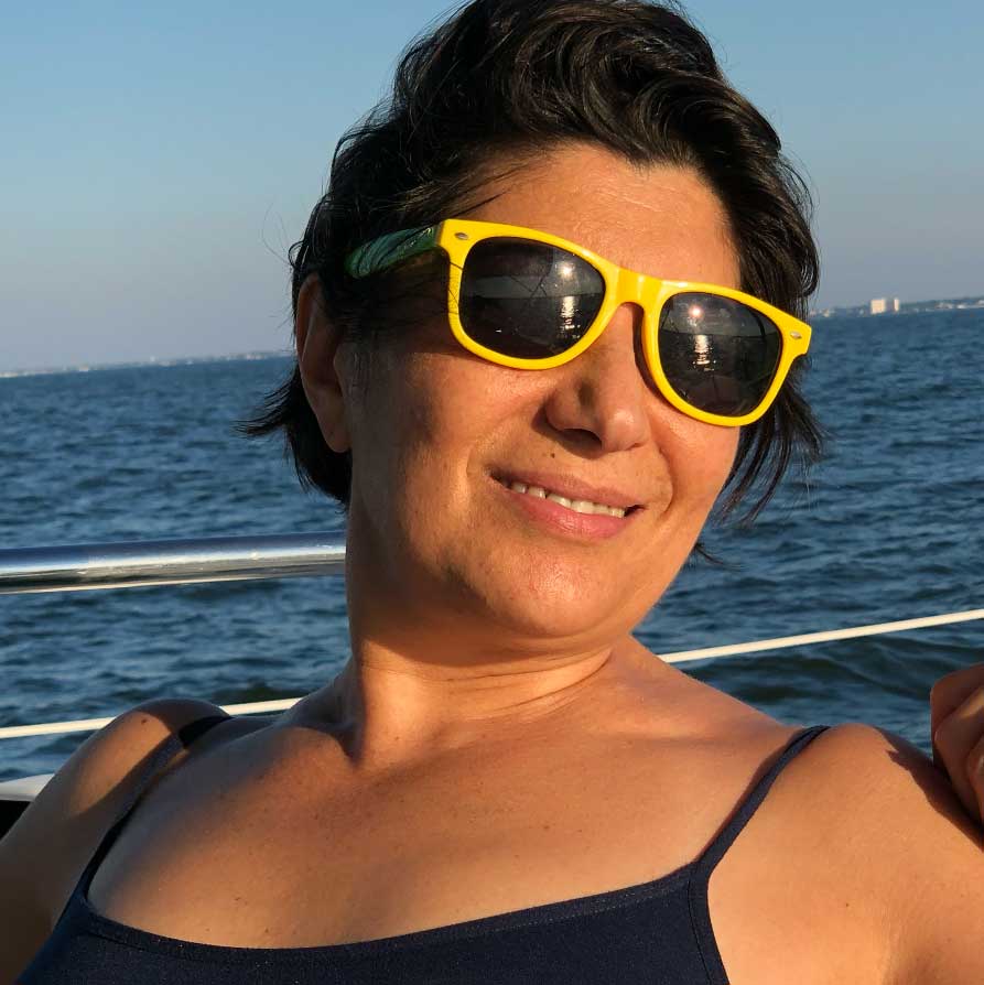 Sarah wearing yellow sunglasses on a boat