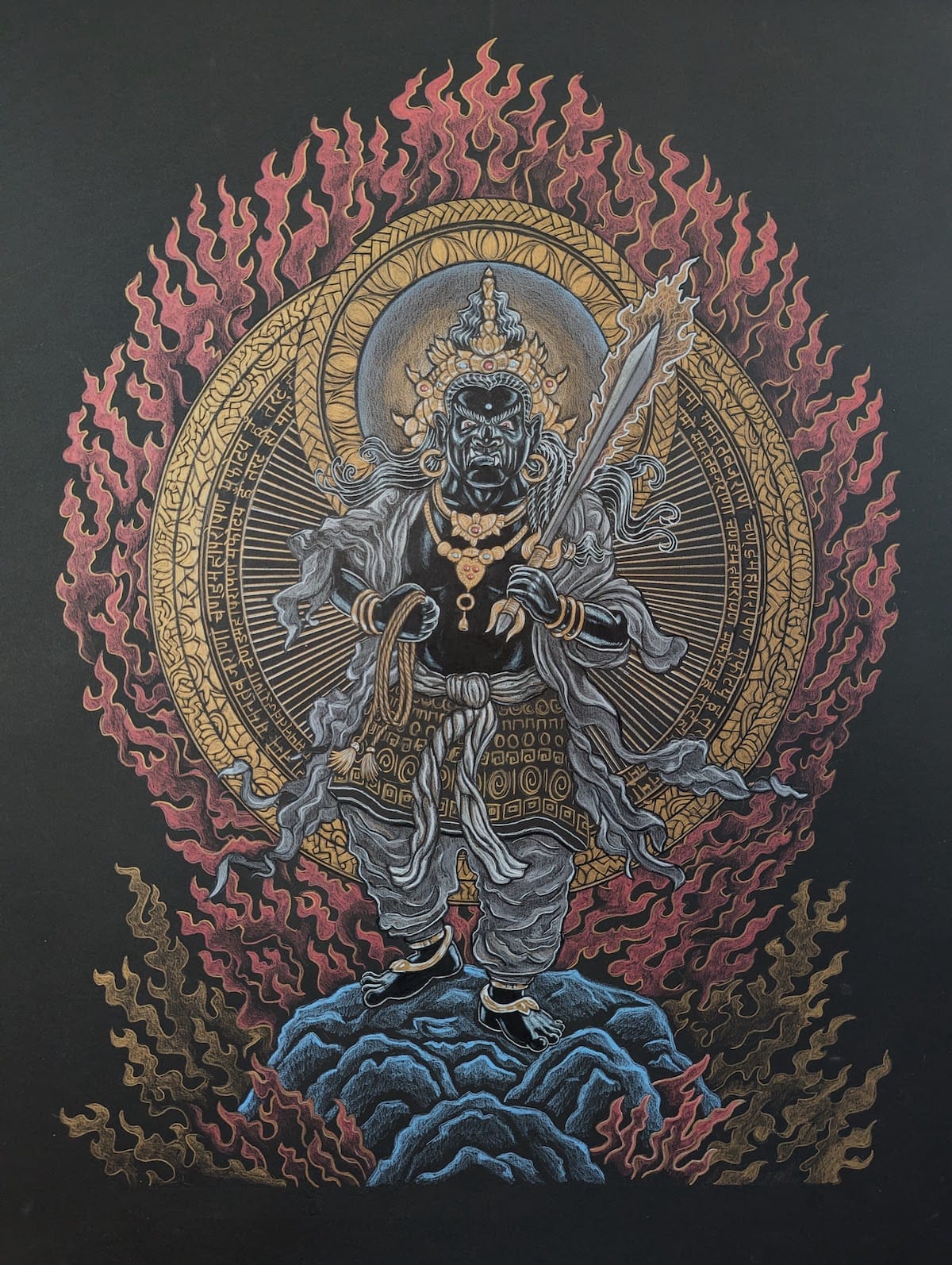 An elaborate drawing of Fudo Myoo, a robust warrior king holding a sword and a rope, wearing a crown and jewels, with two circular gold aureoles behind him, standing on a stone amid flames.