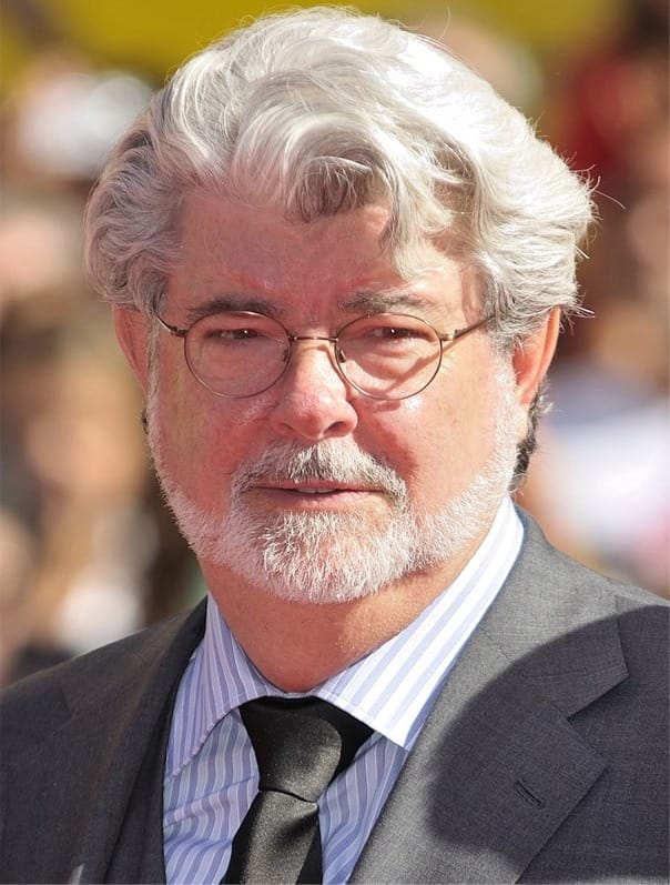 A portrait of filmmaker George Lucas smiling at the 2024 Cannes Film Festival.