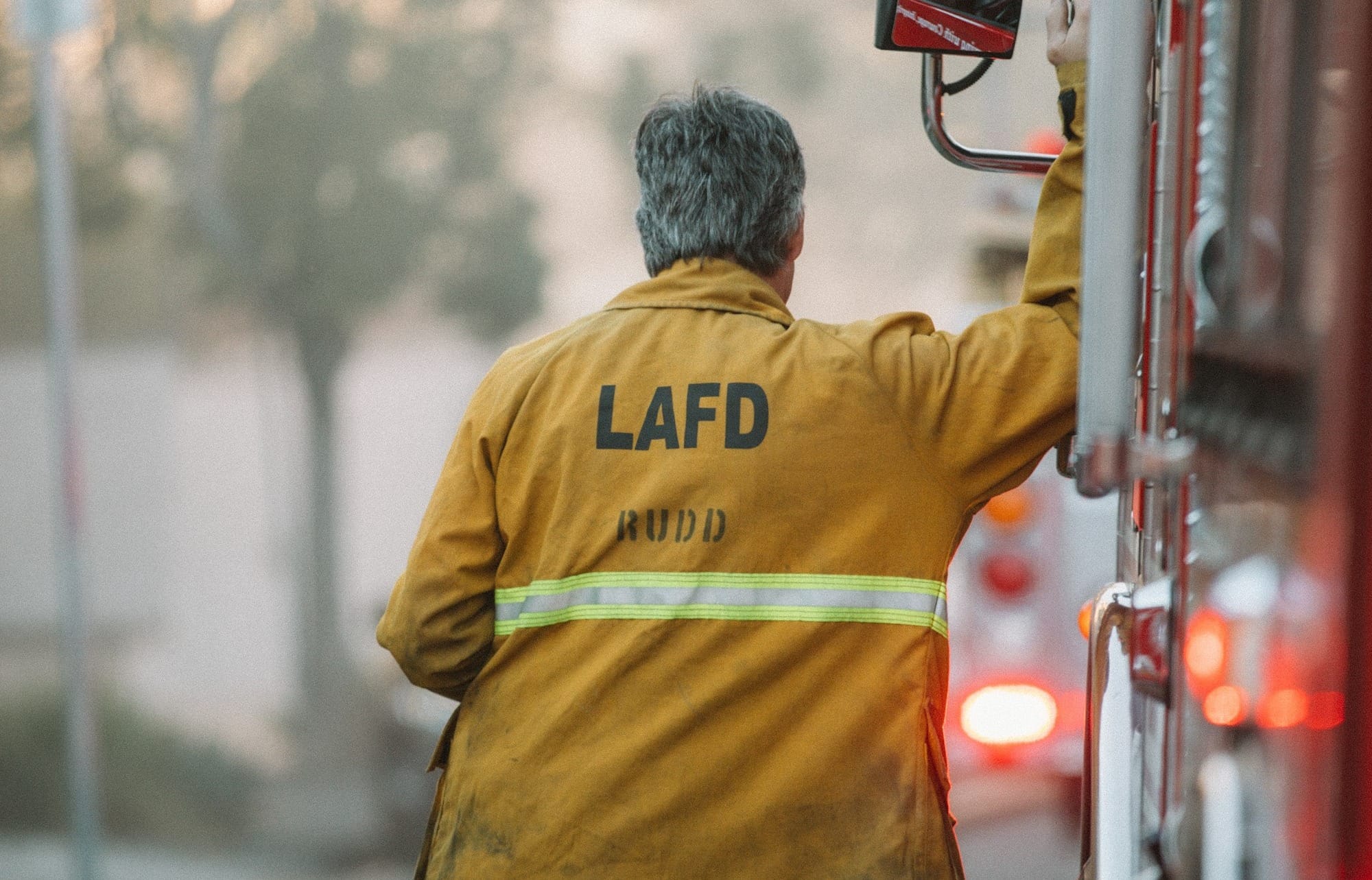 man in yellow and green adidas hoodie holding black and red camera
