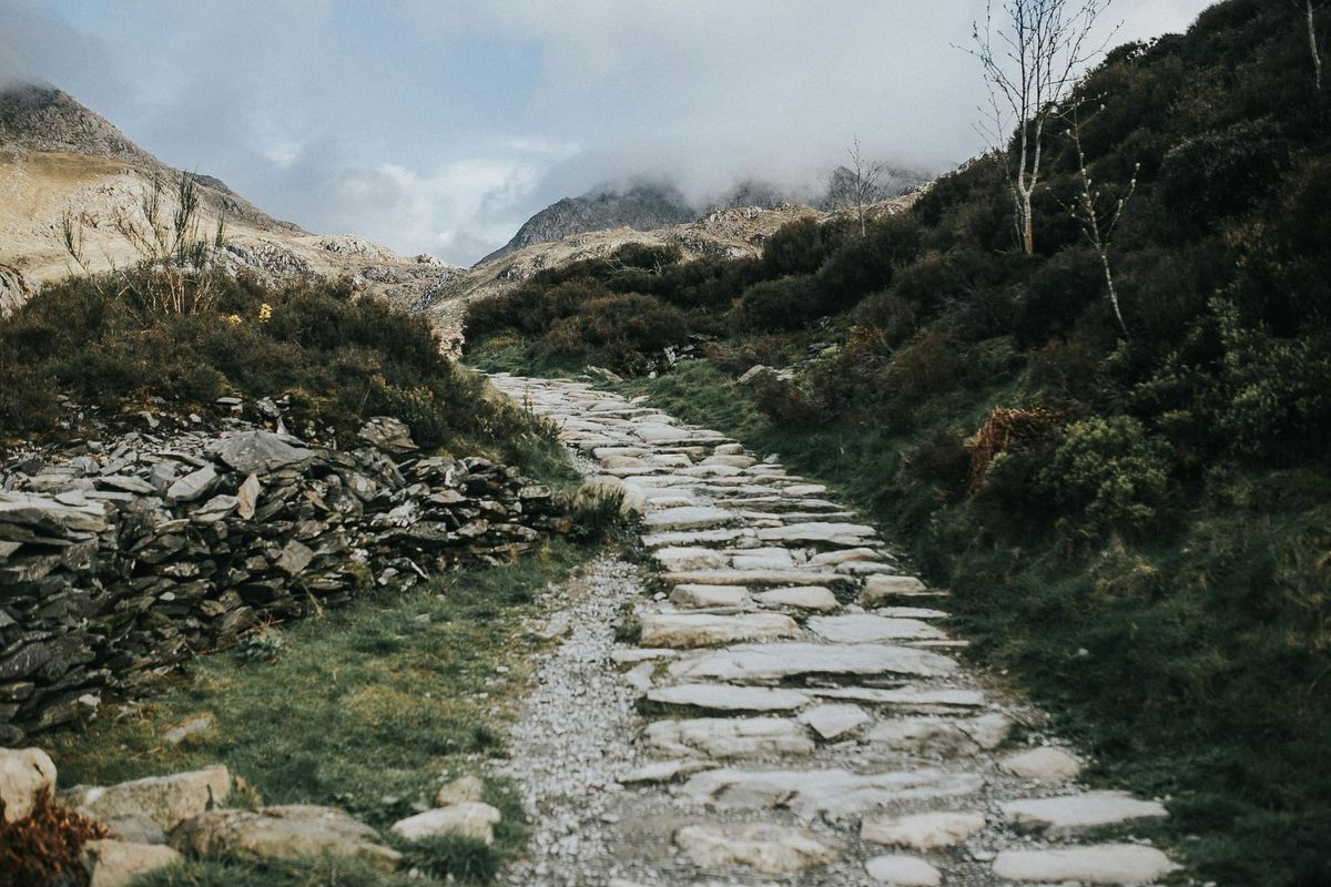 Man sieht einen steinigen Weg ins Ungewisse führend, in die Ferne - wohin? Hauptsache weg von der Hektik.