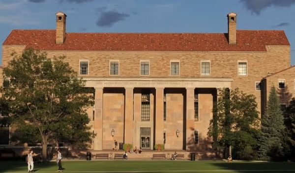Photograph of the west side of the University of Colorado Boulder's Norlin Library, showing a sandstone-sided building with six tall columns and a red-tiled roof.