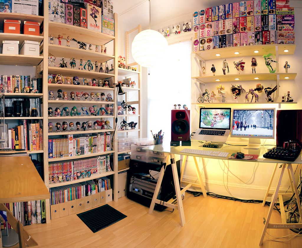 An Otaku's dream study Image of a study with a MacBook Pro laptop set up and lots of Japanese manga books and anime figures