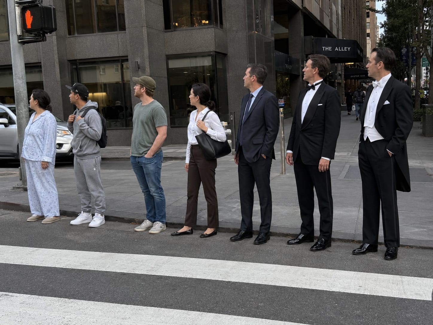 Seven people wait at a crosswalk, their clothes progressing from pajamas to sweatpants, casual wear, suits, tuxedo, and white tie.