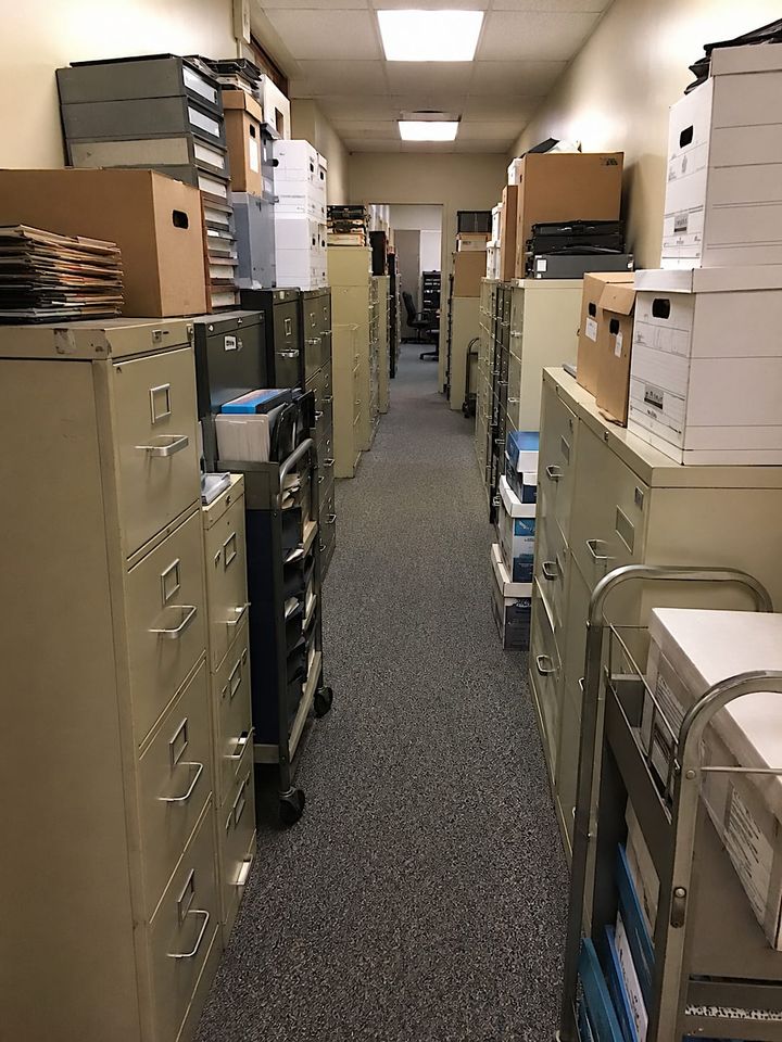 The hallway narrowed near Accounting, as hallways often do when they know too much.