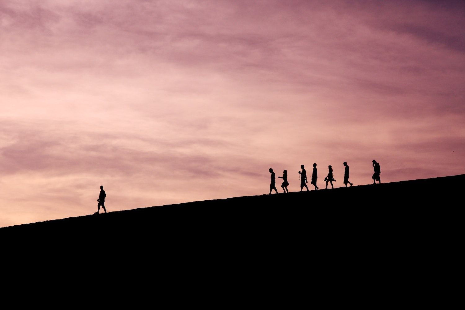 People walking in a line behind a leader. 