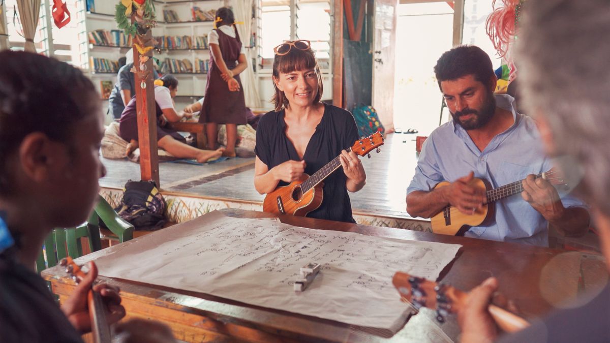 nikki wynn playing ukulele in vava'u library with island kids