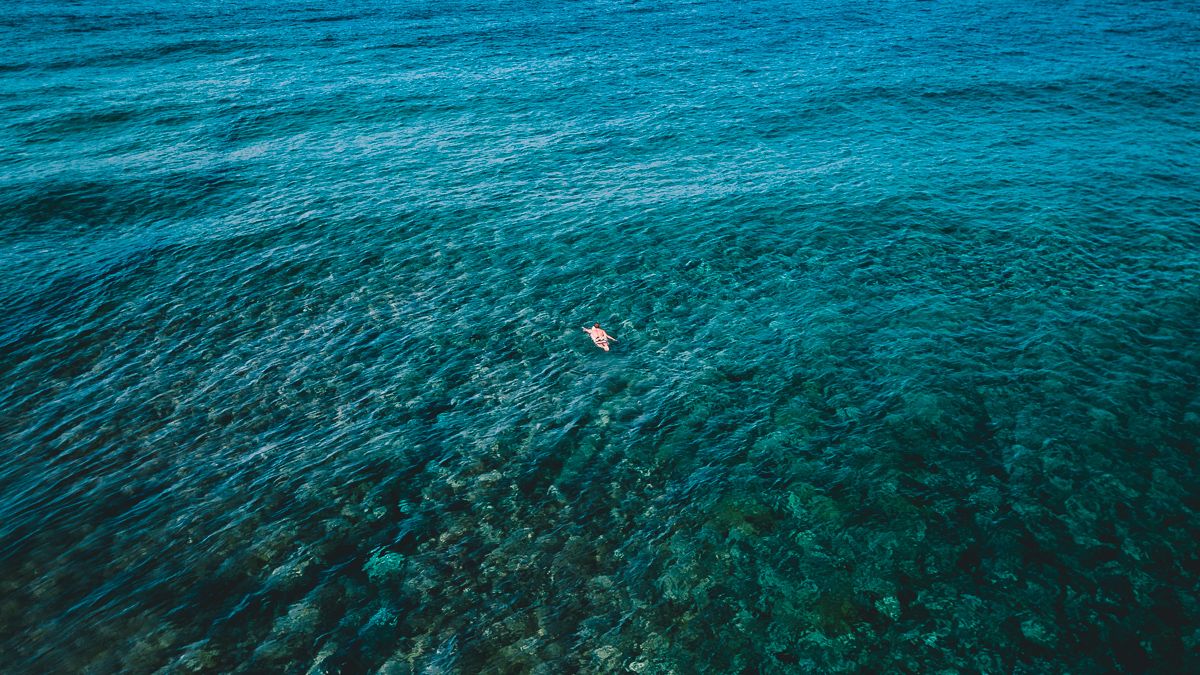 surfer paddling out at billabong tahiti pro surf competition teahupoo