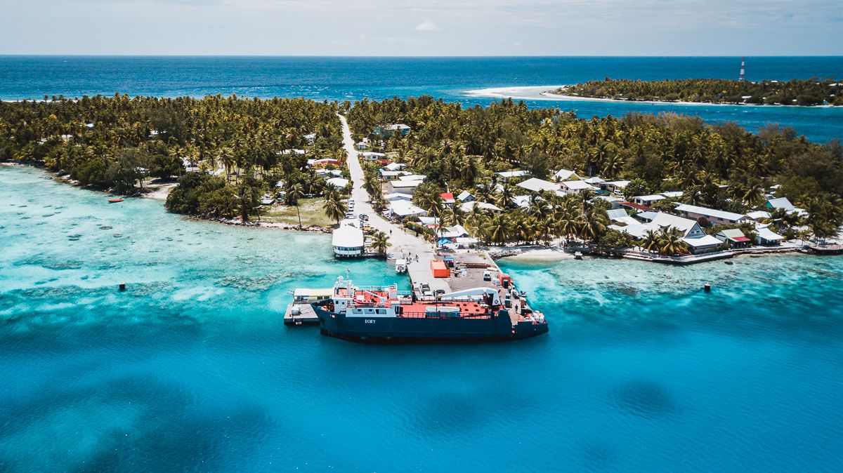drone view of rangiroa atoll in tuamotu and a supply ship at harbor