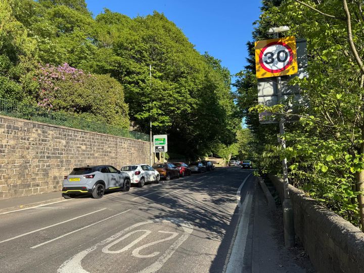 Fallingroyd Road in Hebden Bridge with parked cars beneath a 30mph speed limit sign.