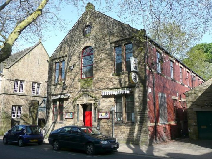 Stone building with arched windows on a Calder Valley street.