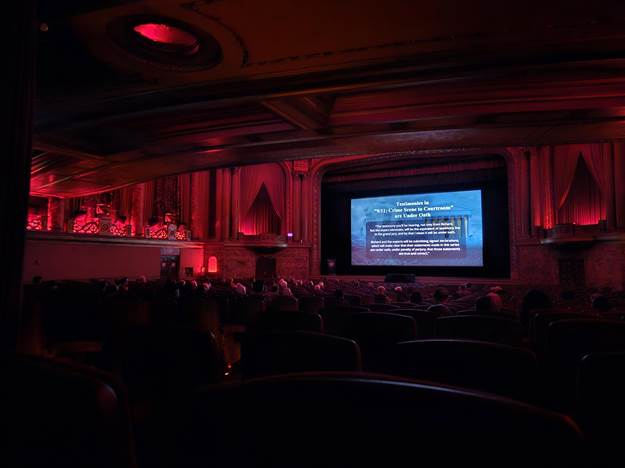 A room with a large screen and red lights
AI-generated content may be incorrect.