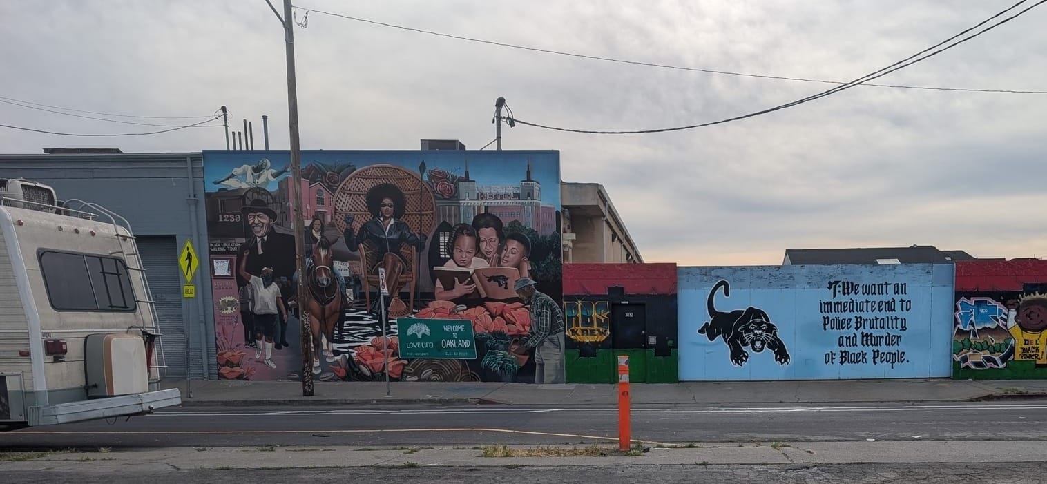 Another panther mural against a blue background, viewed from across the street.