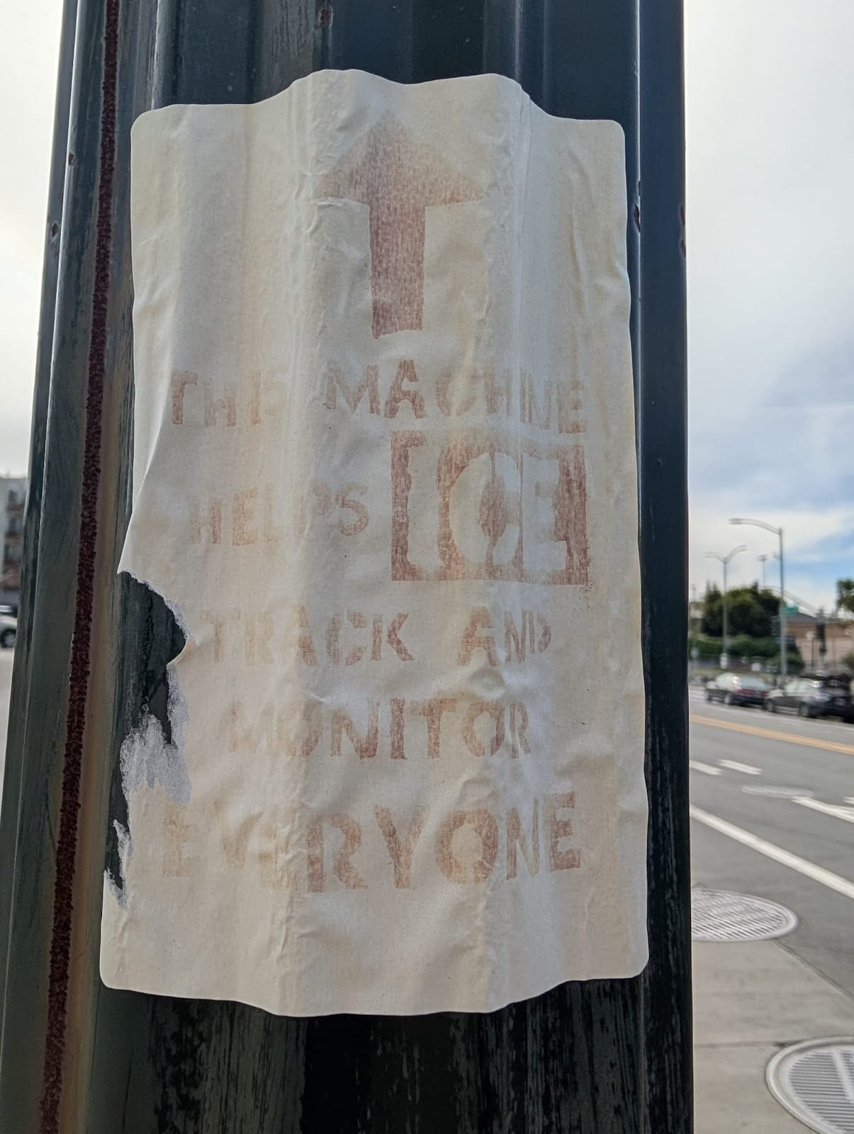 A faded sign that reads, "THIS MACHINE HELPS ICE TRACK AND MONITOR EVERYONE."