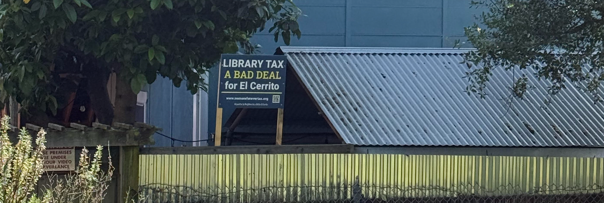 Another "library tax a bad deal for El Cerrito" sign, next to a shed and a sign announcing you're under video surveillance.