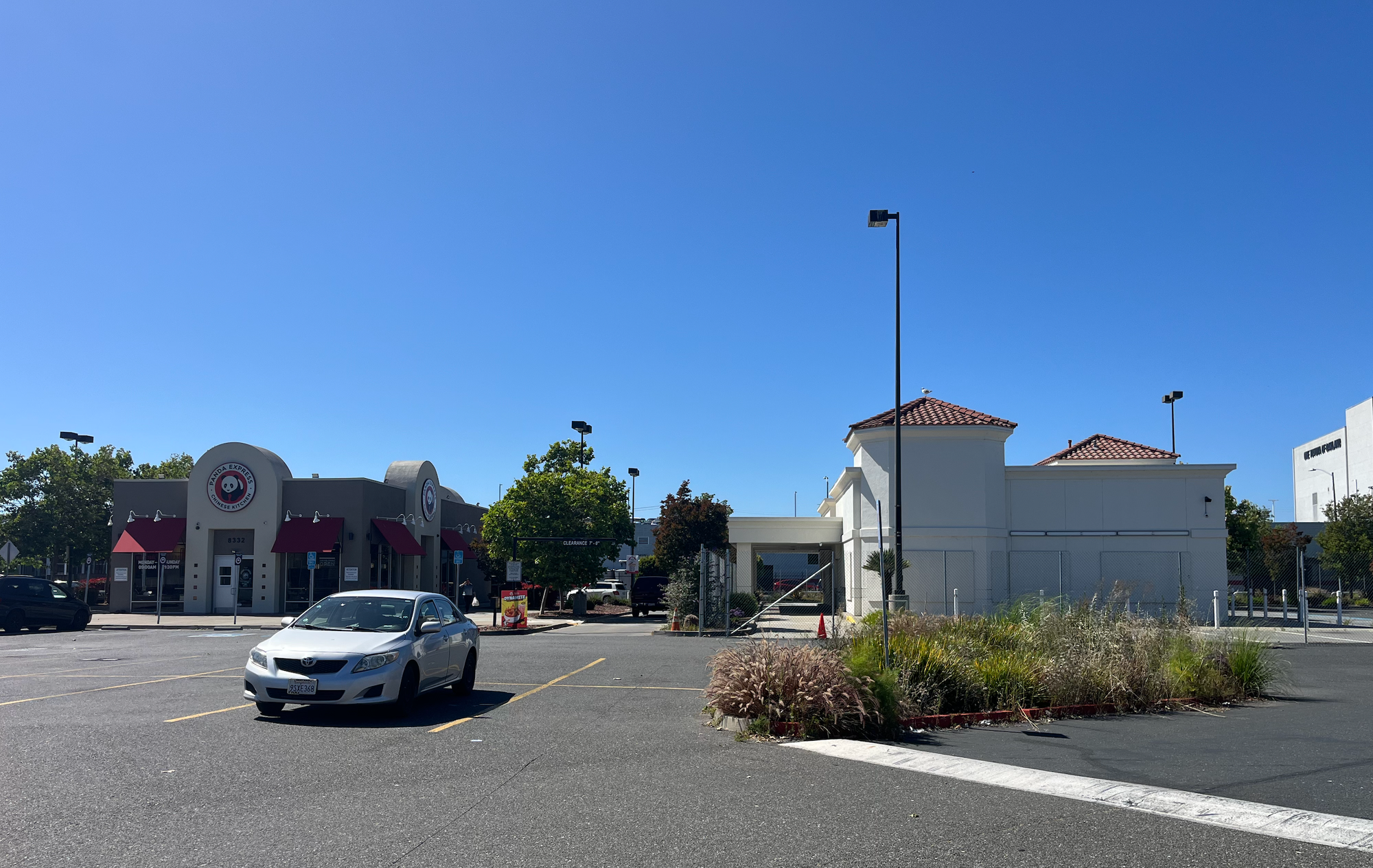 A parking lot, with the In-N-Out building on one side and a Panda Express nearby.