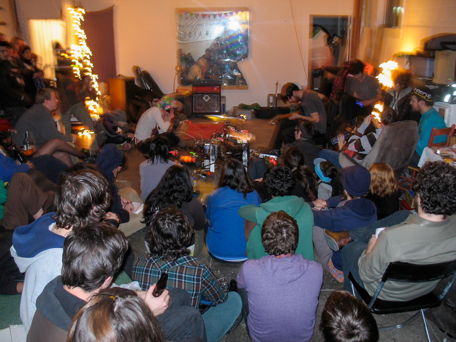 crowd out of focus sitting on the floor listening to music