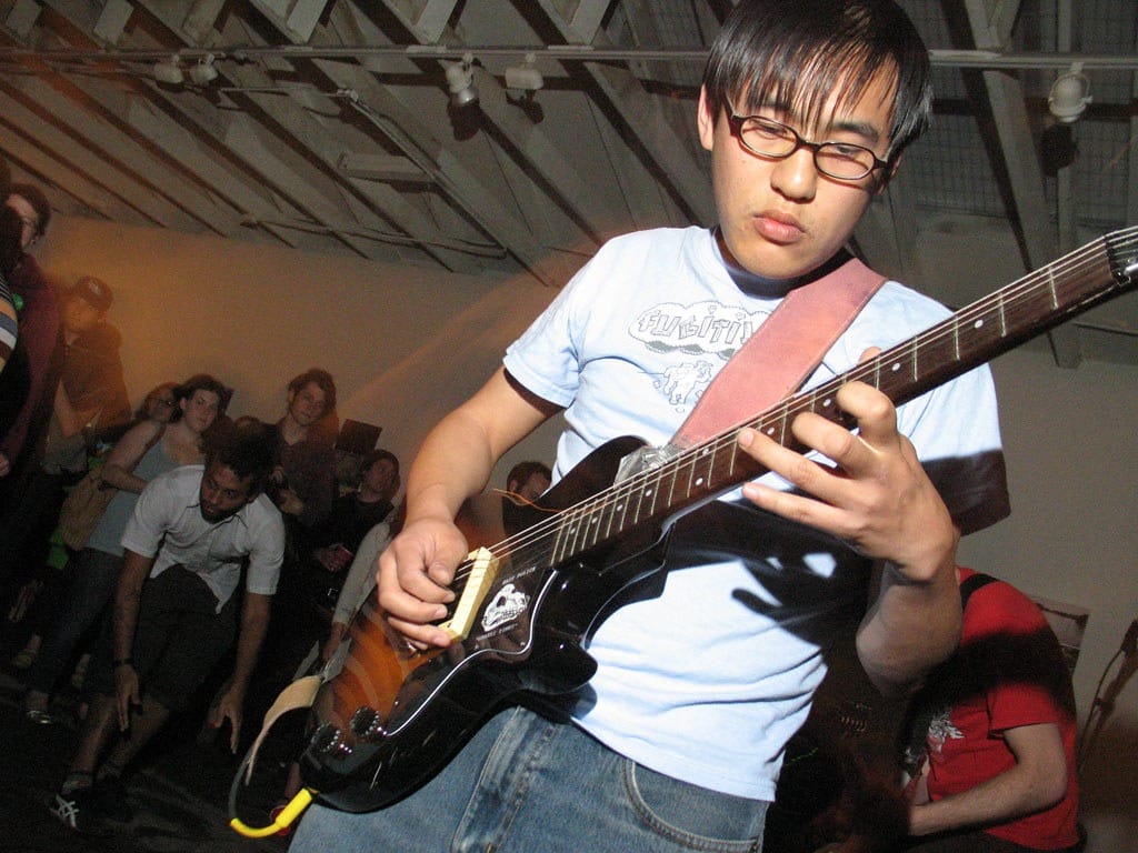 a guy playing guitar intensely