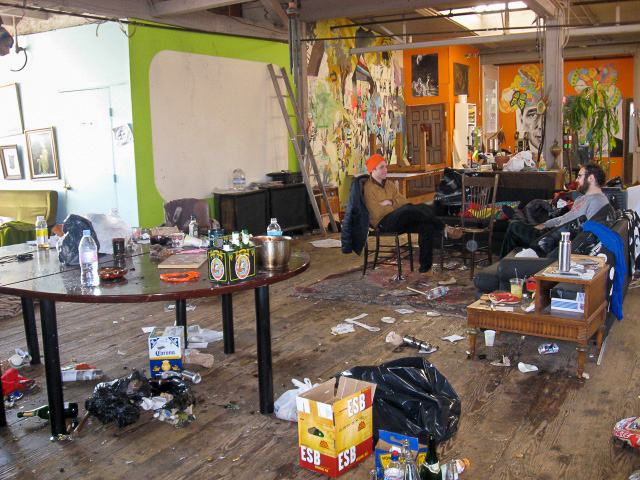 a messy post-party space, with a few chilling post-revellers